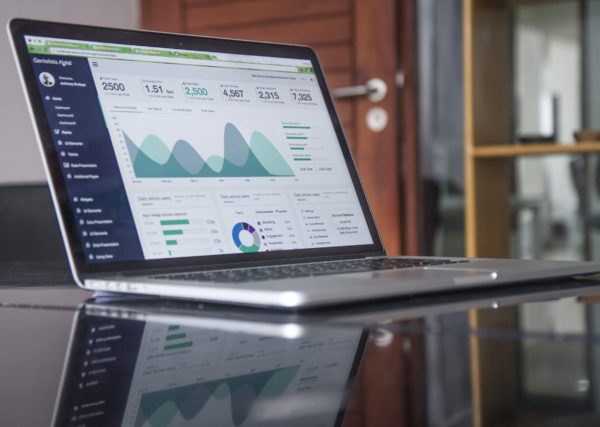 Laptop on table with Google Analytics page open, representing marketing data and analysis.