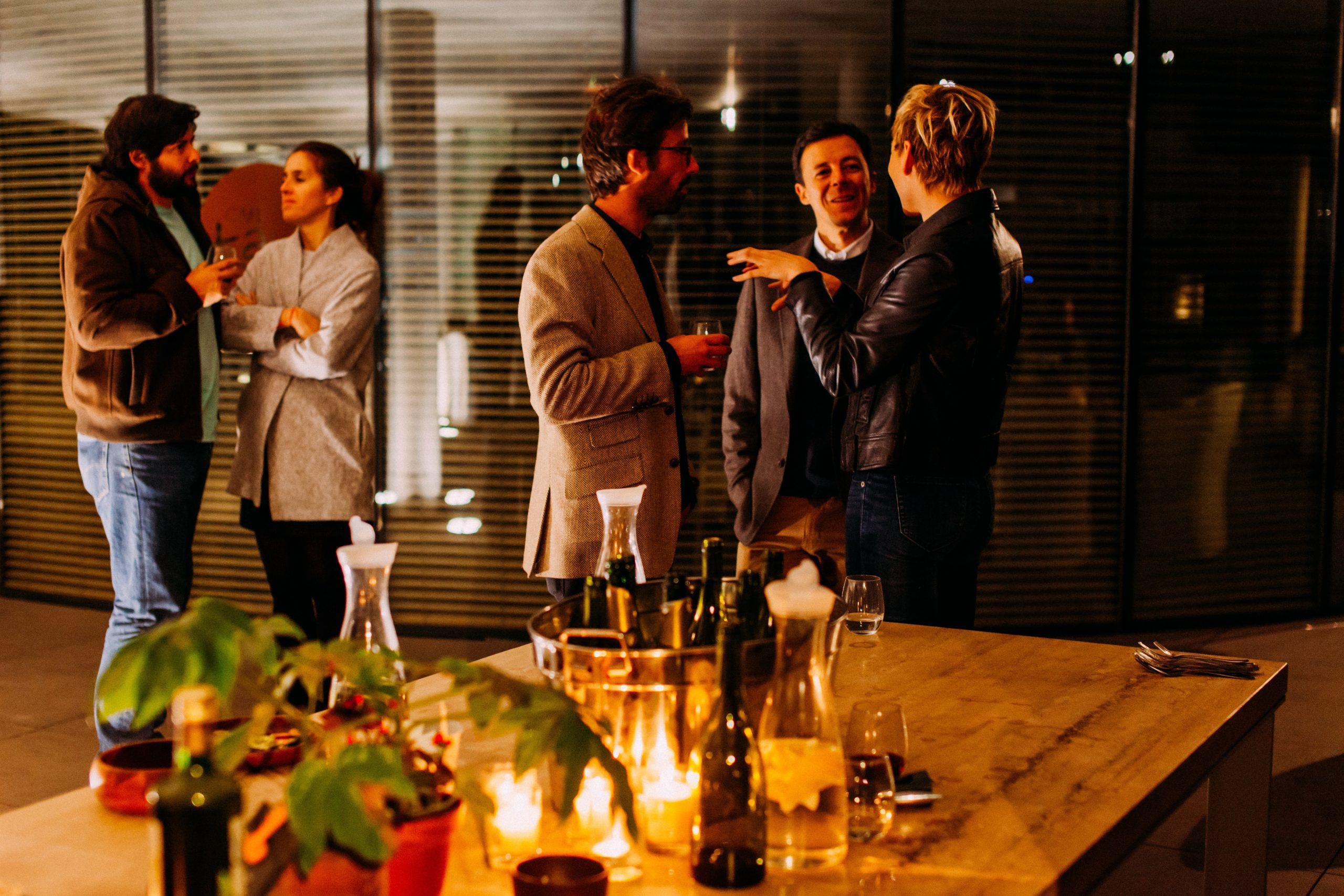 Five people standing, talking to each other in a networking event.