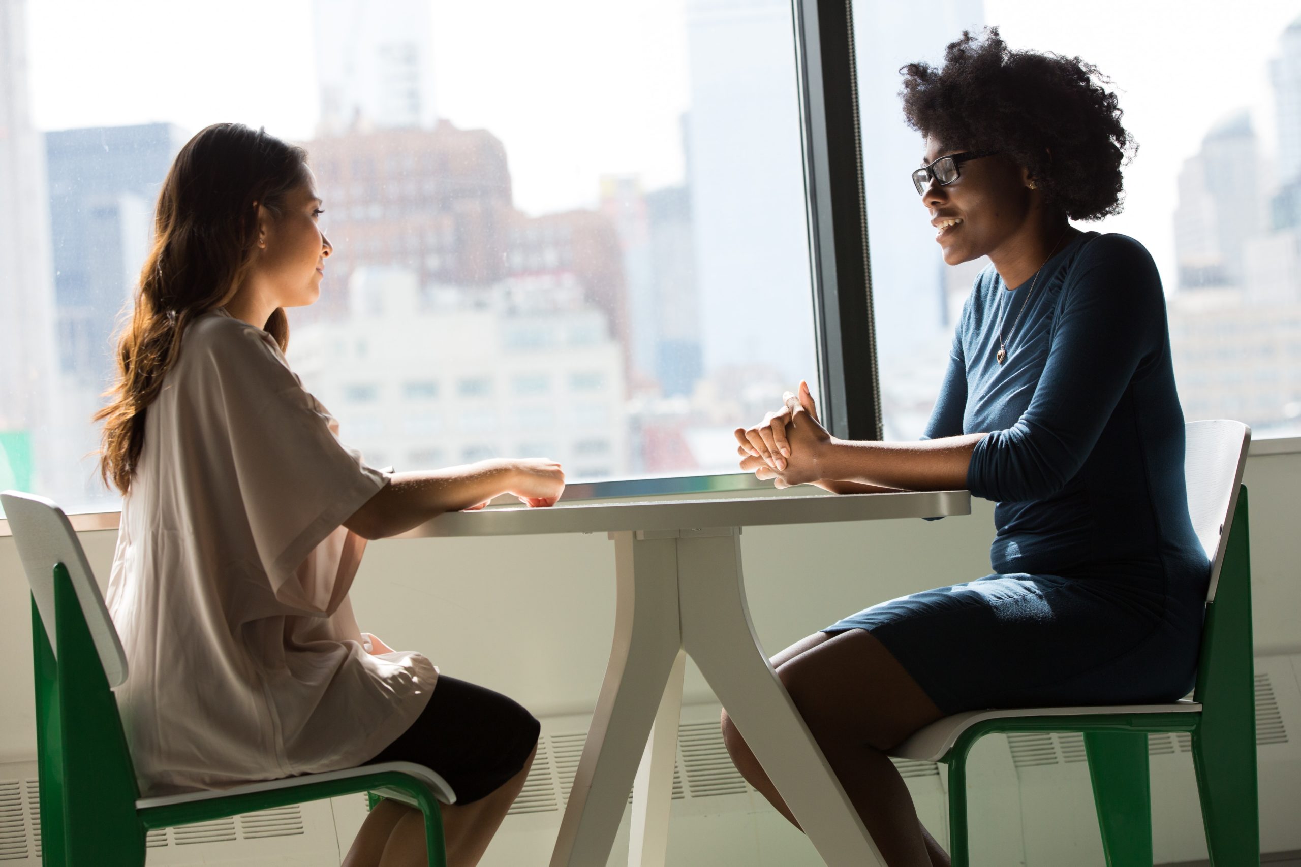 Two women talking, one asking the other for a LinkedIn recommendation.