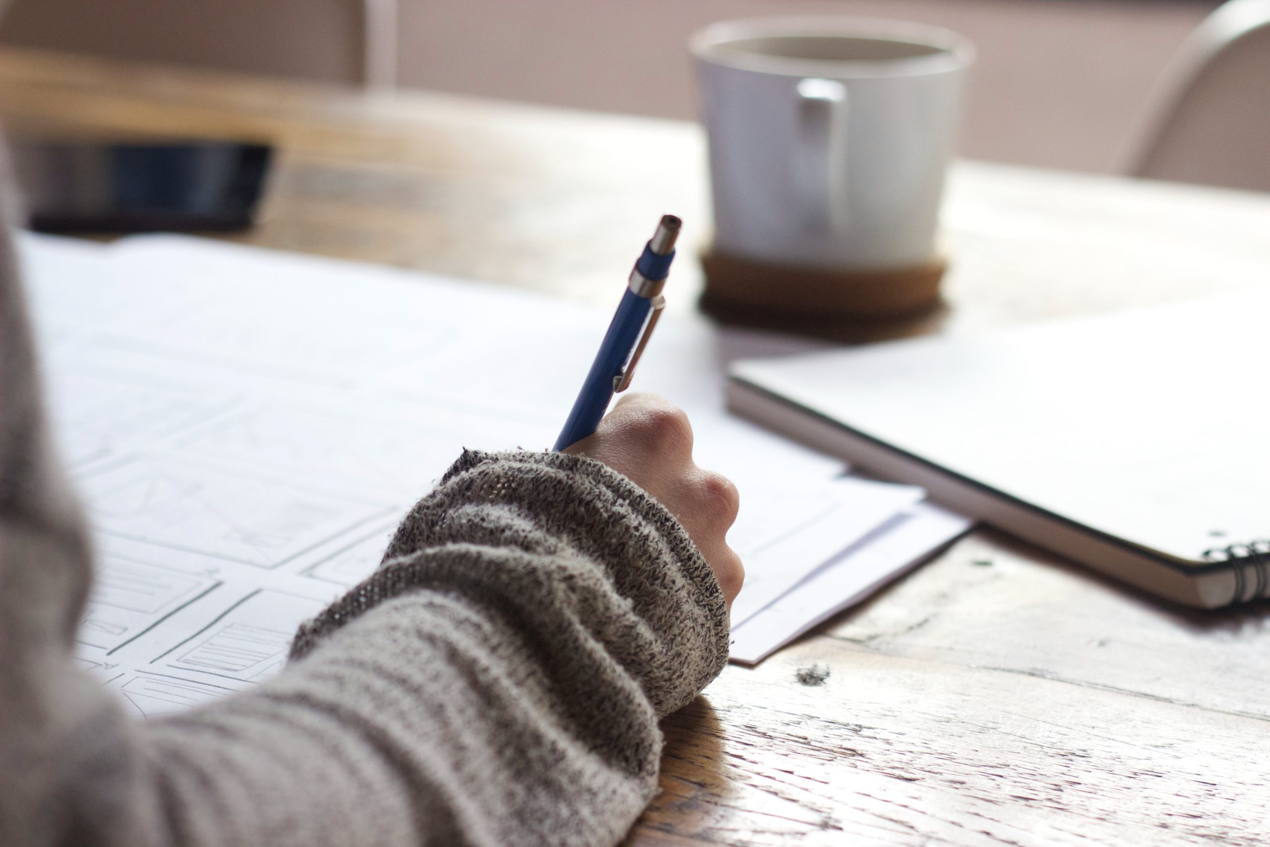 Hands writing notes on LinkedIn personal brand strategies.